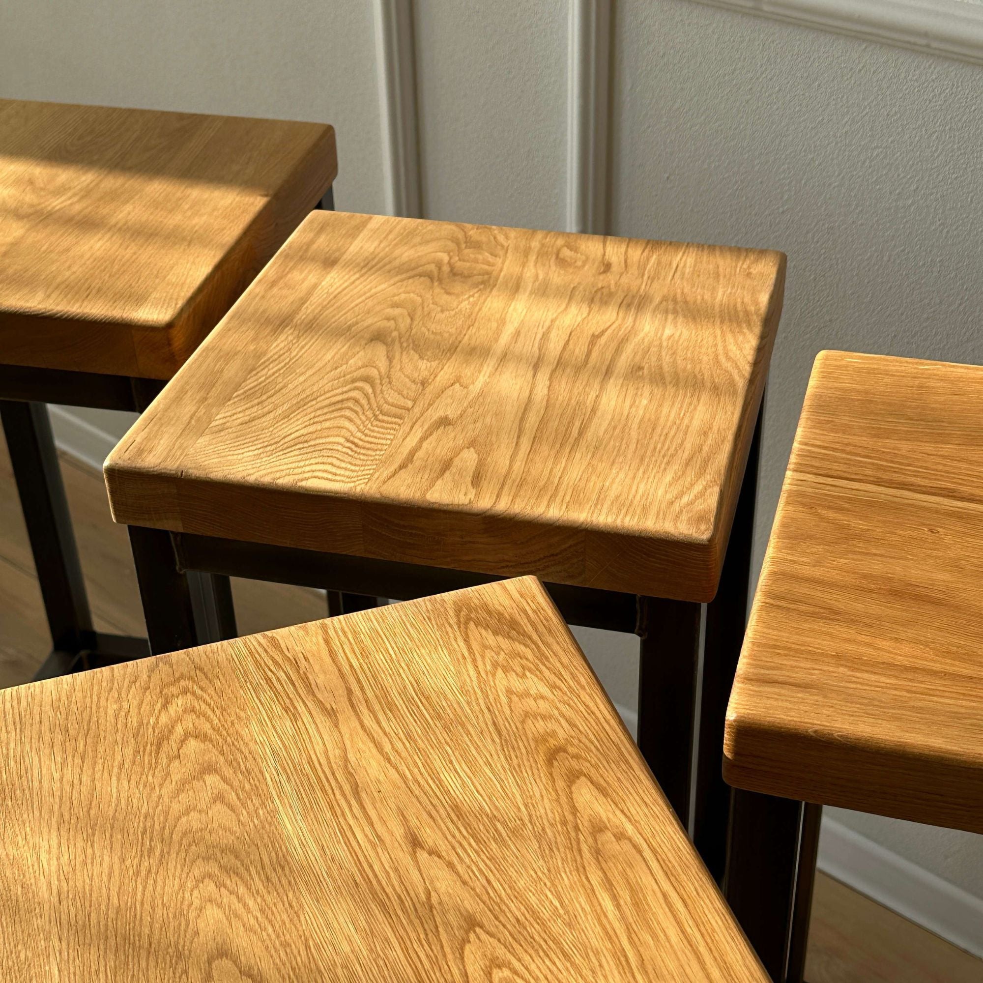 Barhocker mit massiver Holzsitzflaeche und minimalistischem Metallgestell im Industrial Chic