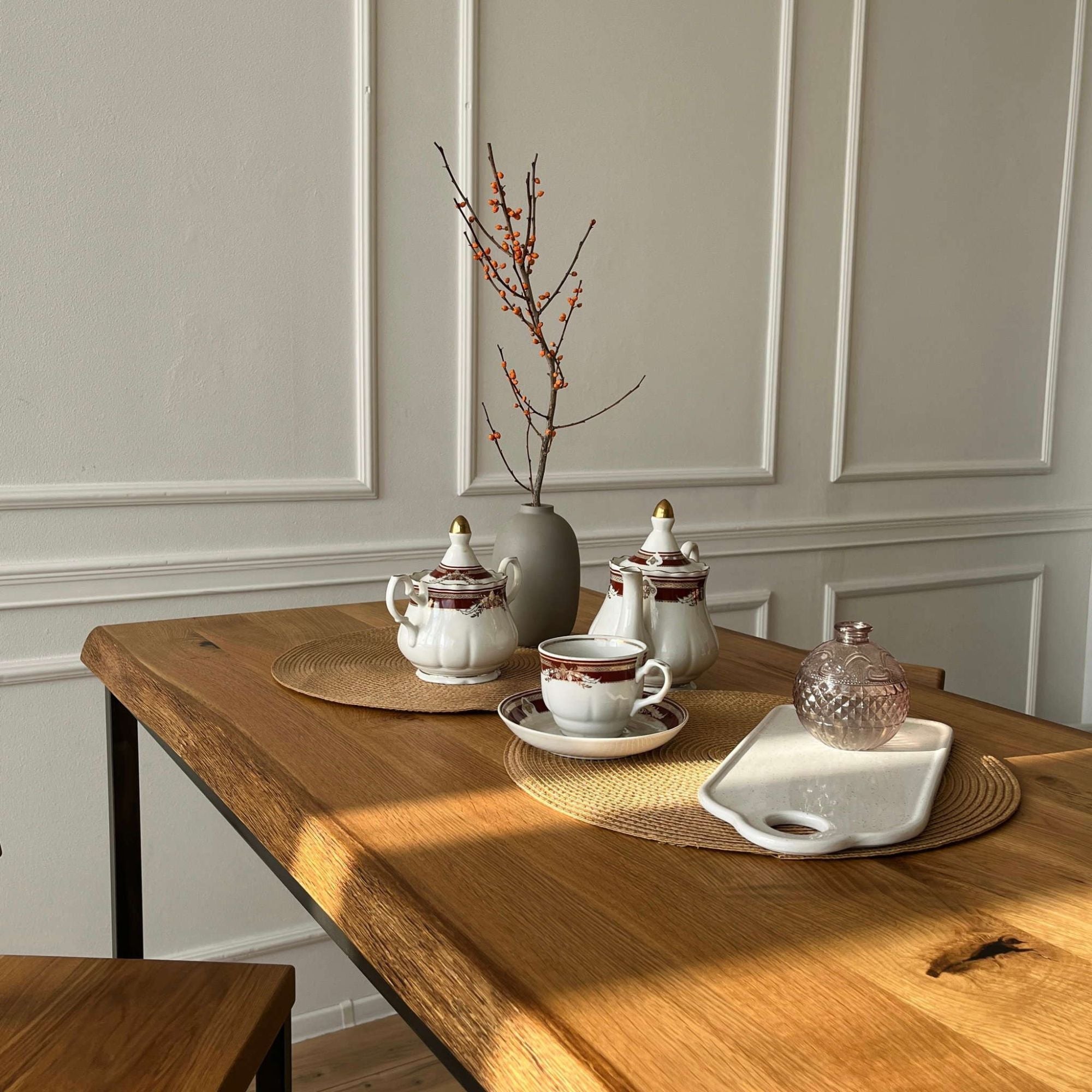 Stehtisch mit robuster Holzplatte und Metallgestell, dekoriert mit Teeservice und modernen Accessoires