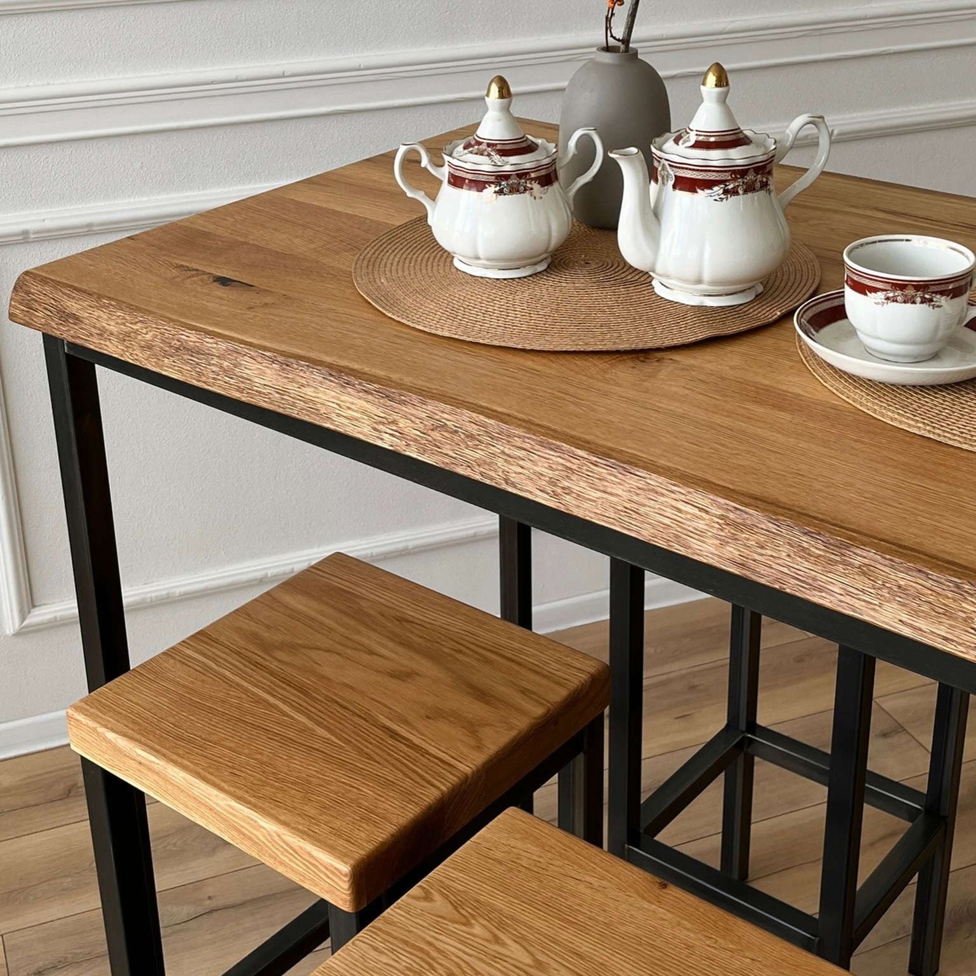 Rechteckiger Bartisch mit vier passenden Hockern aus Holz und schwarzem Stahlgestell im minimalistischen Look