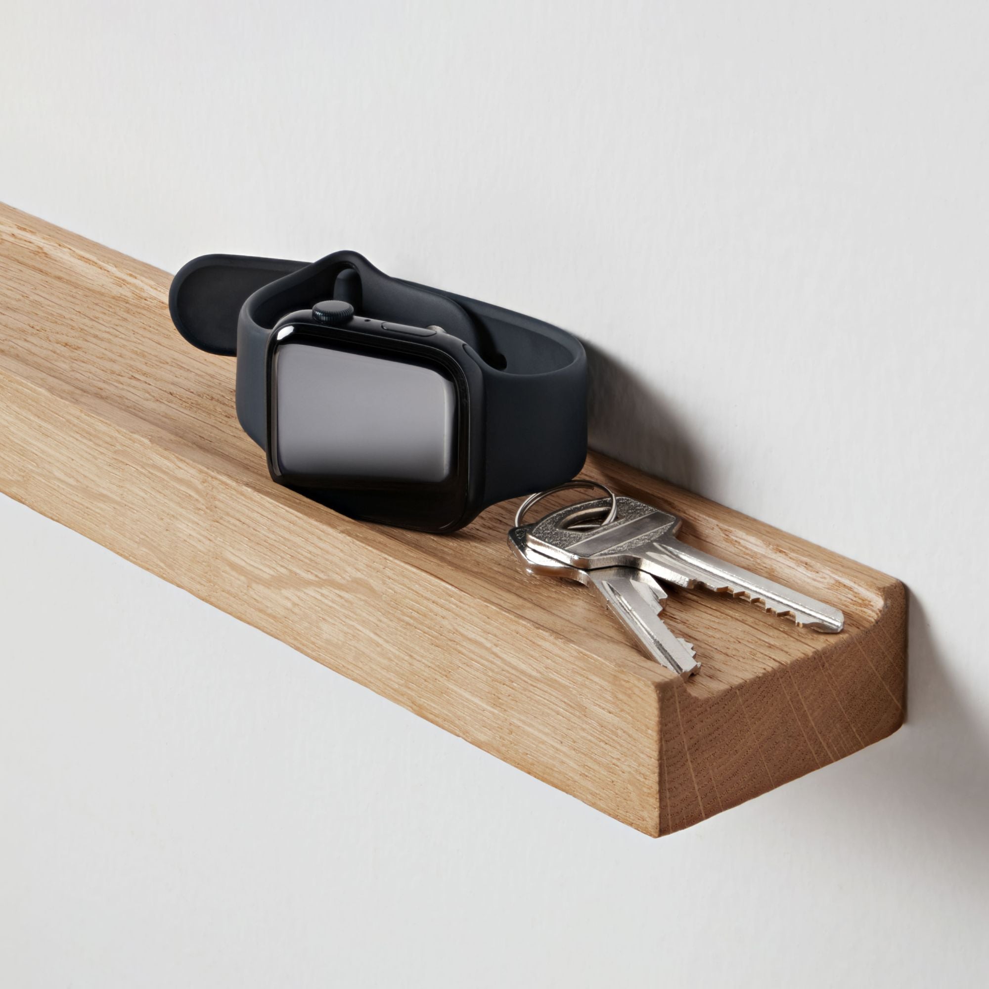 Nahaufnahme eines kleinen Holzregals für Schlüssel und Uhr