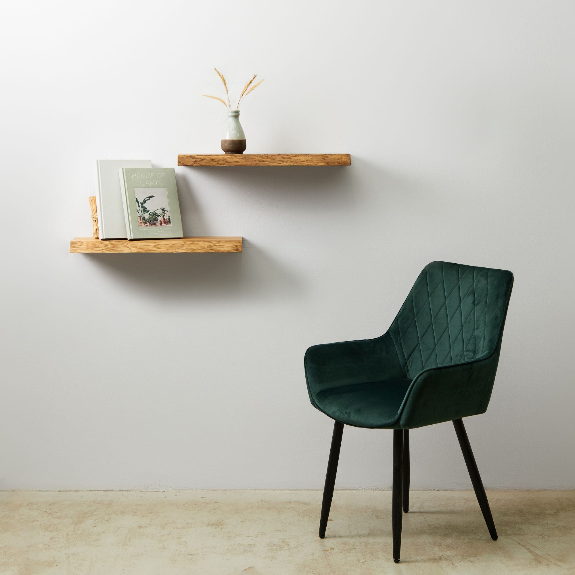 Wandregale Eiche mit Buechern, Vase und Sessel im modernen Wohnzimmer