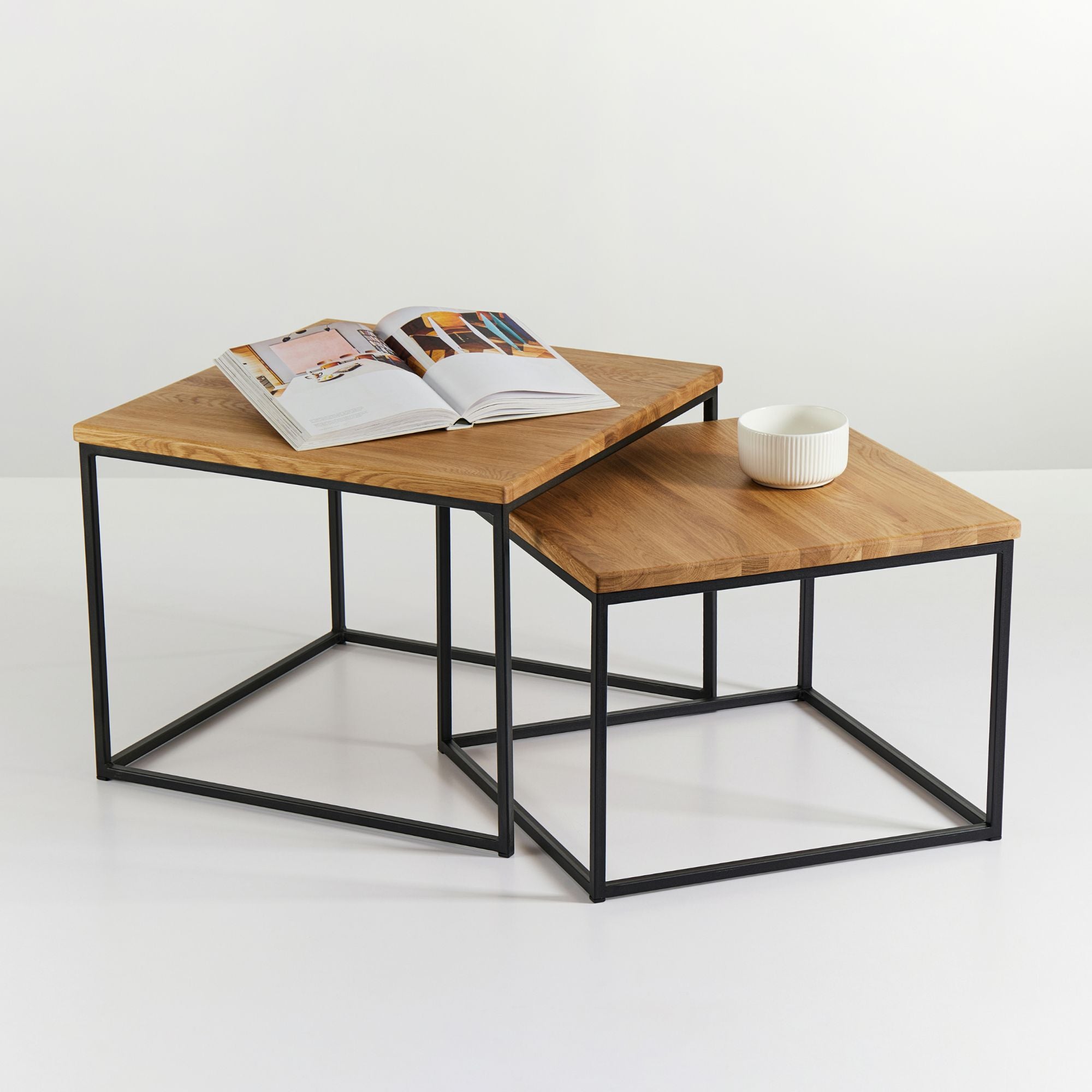 Industrial Couchtisch Set aus Eiche massiv mit schwarzem Stahlgestell, dekoriert mit Schale und Wohnzeitschrift.