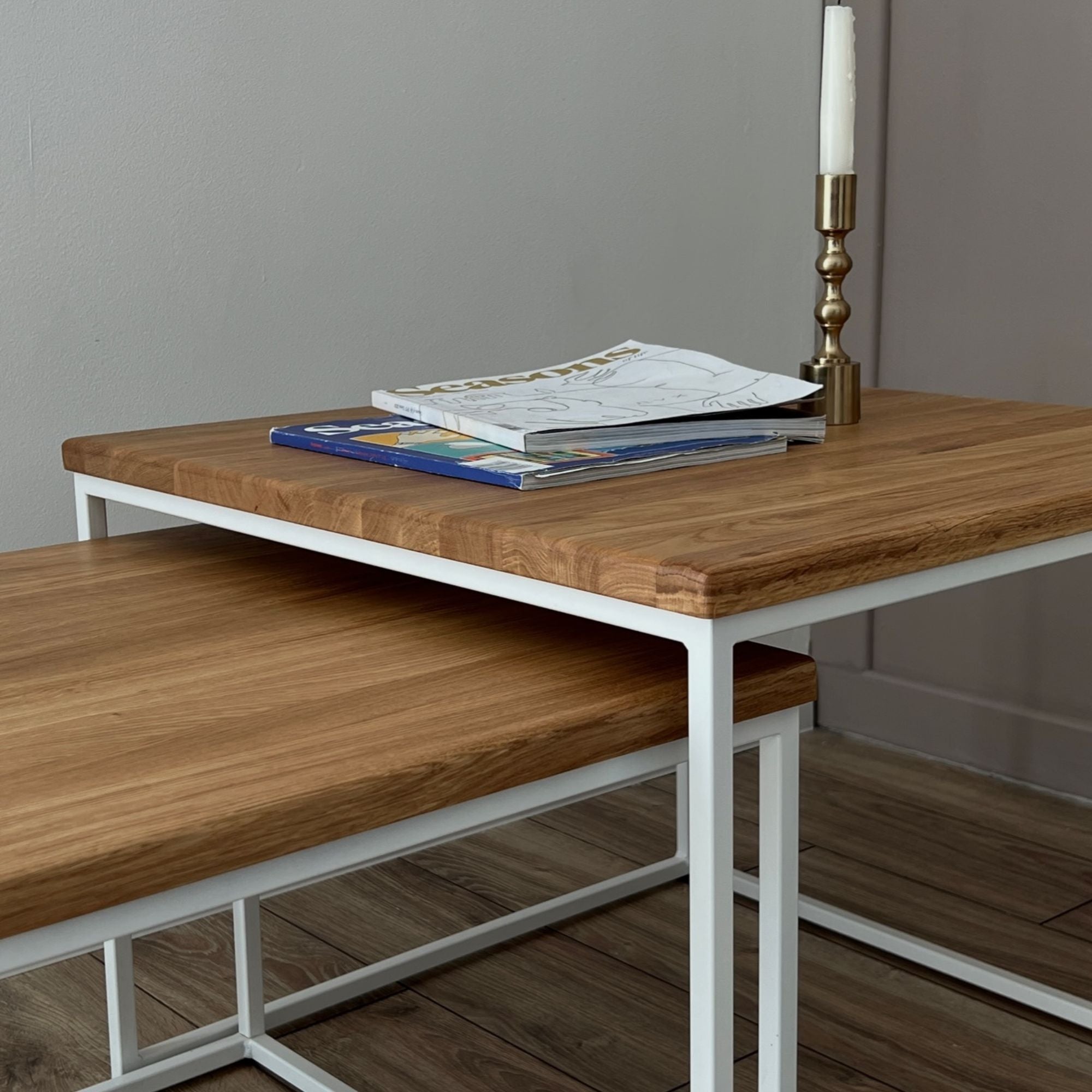 Designer Beistelltisch 2-teilig mit heller Eiche Tischplatte und weiß lackiertem Metallgestell im modernen Wohnzimmer.