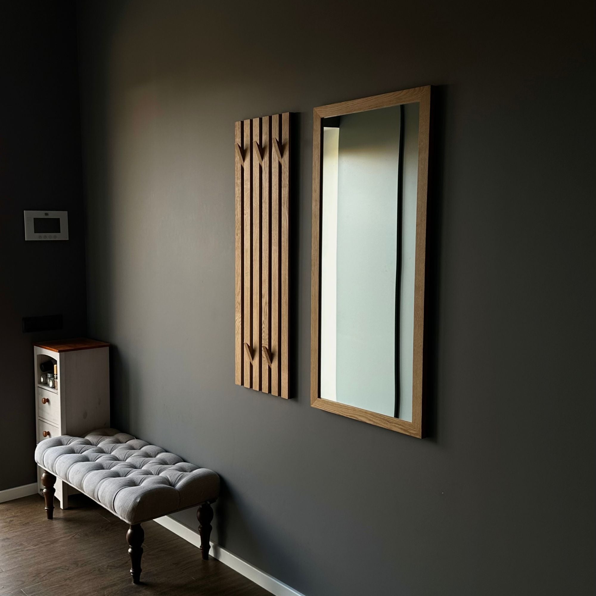 Elegantes Garderobenpaneel aus Holz mit Spiegel im modernen Eingangsbereich.