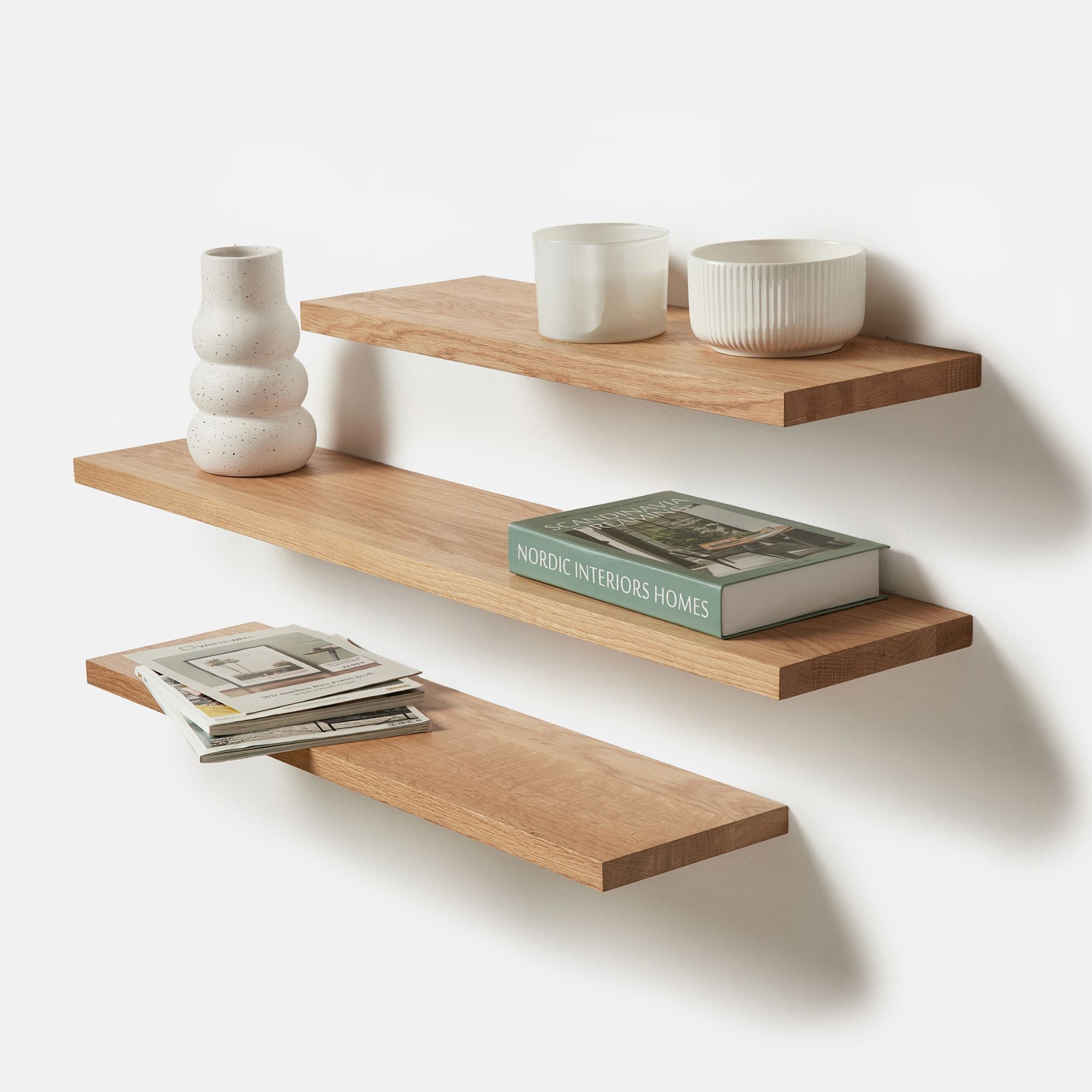 Schwebendes Wandregal aus massiver Eiche mit moderner Deko und Büchern – elegantes Regal für Wohnzimmer oder Büro.