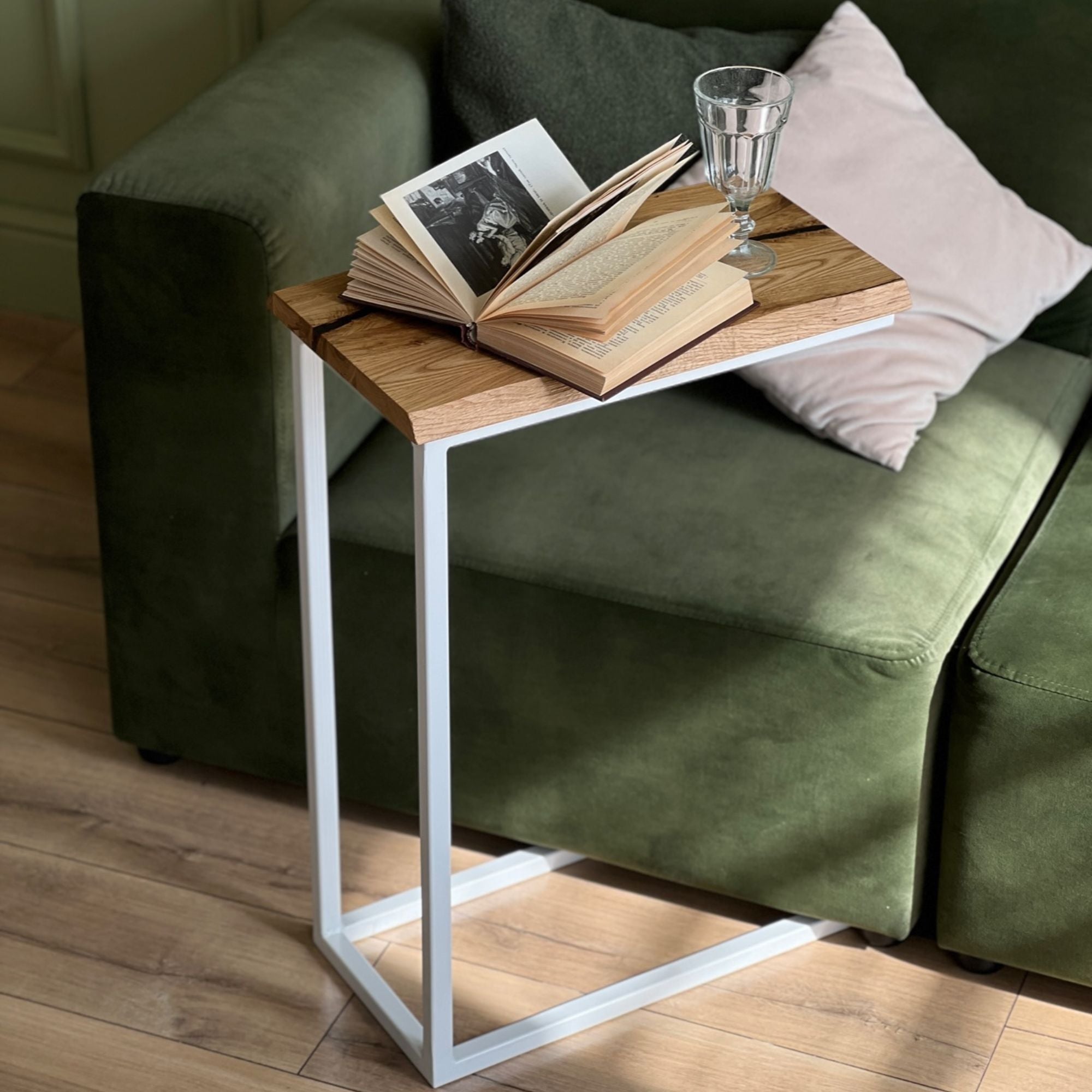Beistelltisch aus Holz und Metall neben grünem Sofa