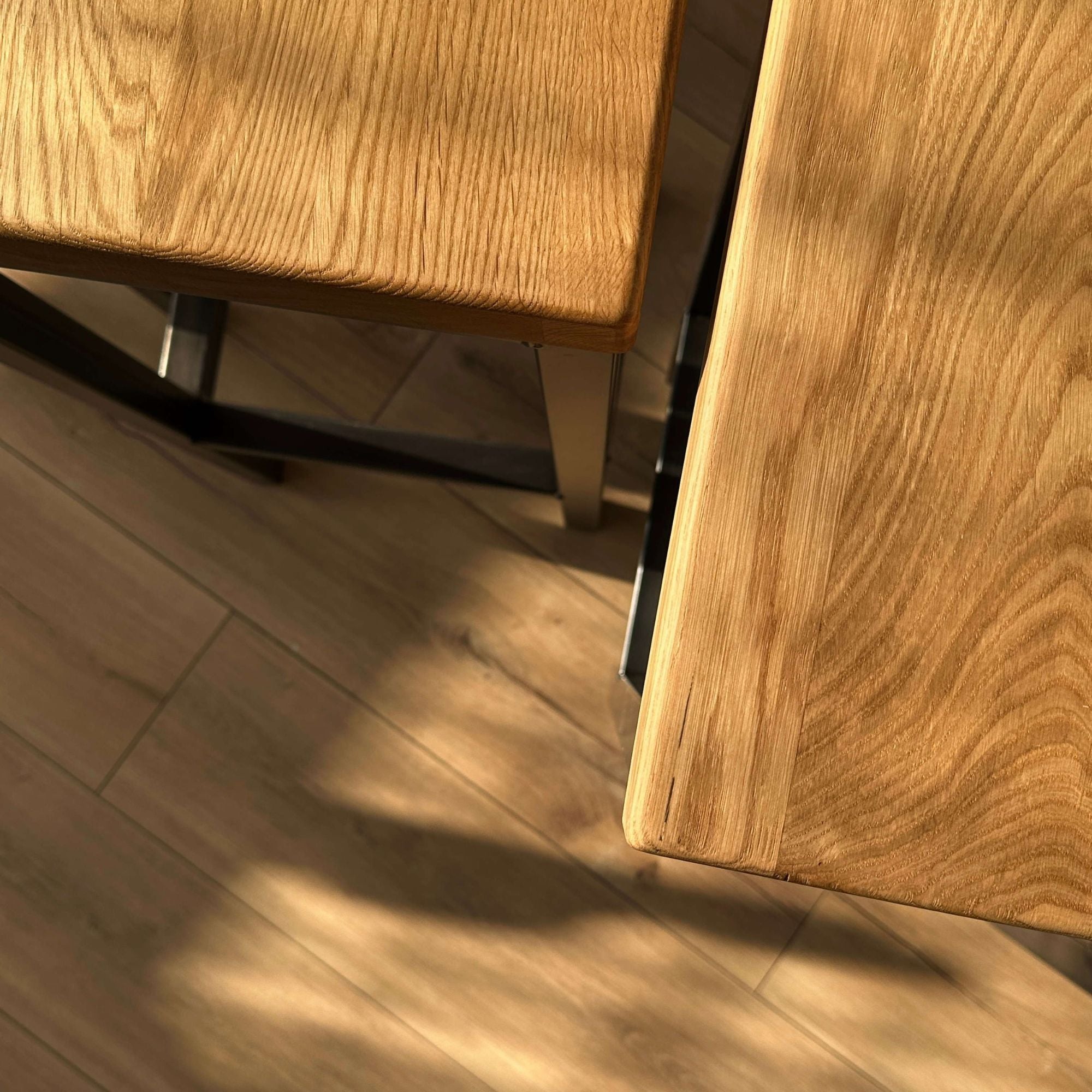 Nahaufnahme der Holzoberflaeche eines Barhockers mit natuerlicher Maserung und stabilem Metallrahmen