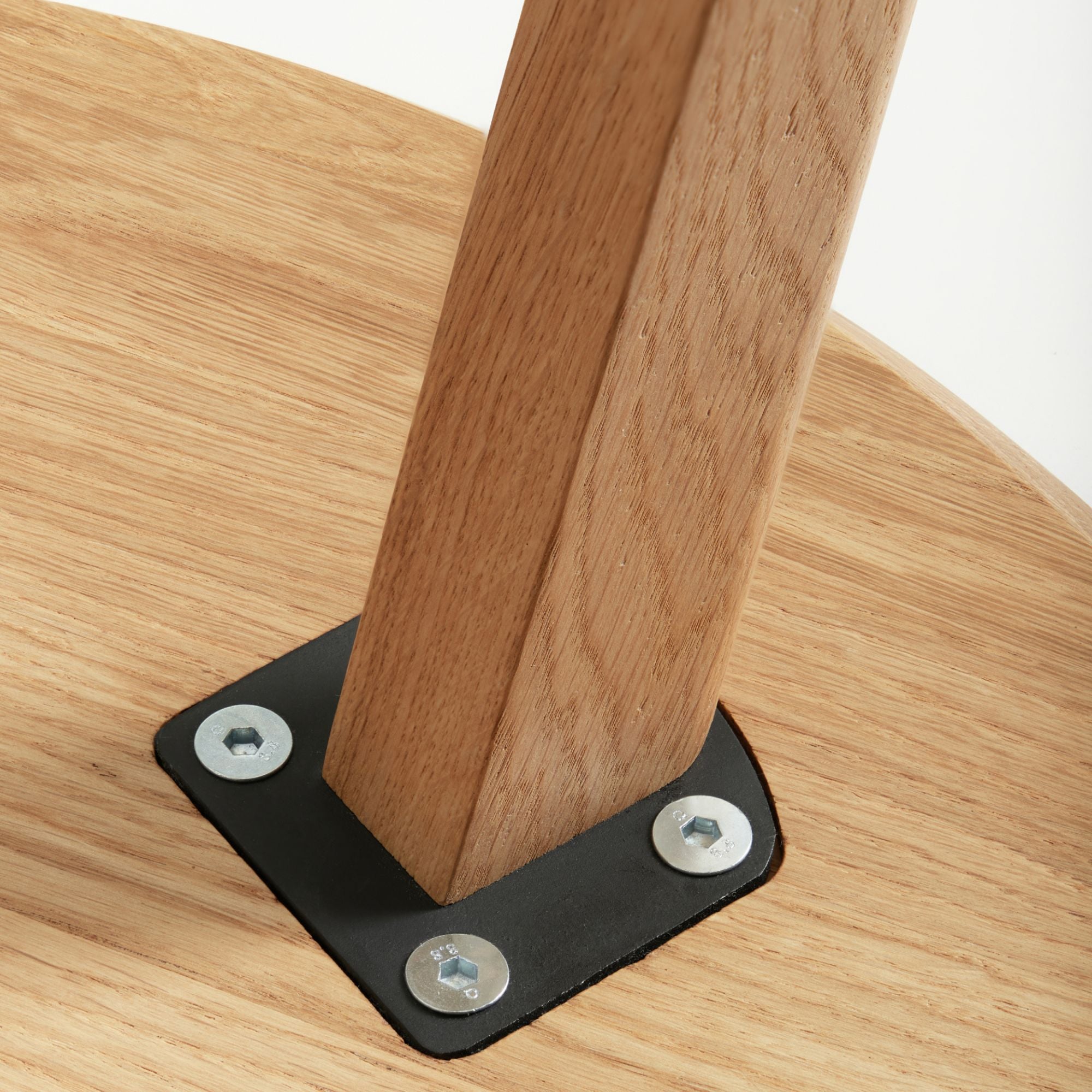 Unterseite eines Holztisches mit Metallverstärkung und Schrauben für stabilen Stand