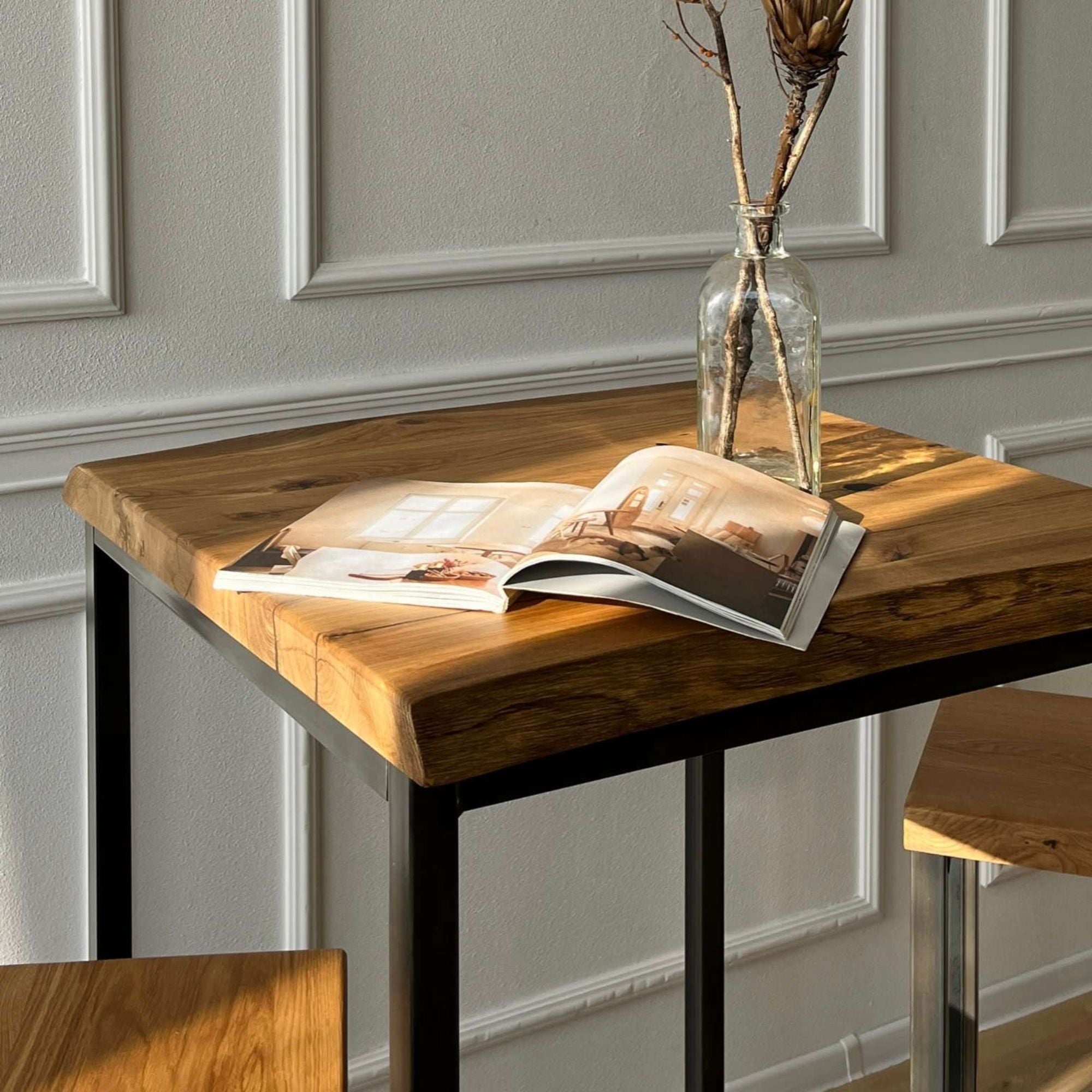 Nahaufnahme des Bartisches mit dicker Massivholzplatte und schwarzem Metallgestell